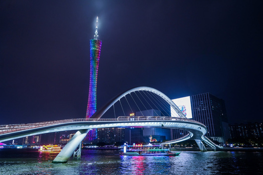 Guangzhou Guangdong Province China 24 February 2024 View of the illuminated Canton Tower and the curved Liede Bridge over the Pearl River at night. Guangzhou Guangdong Province China 24 February 2024 View of the illuminated Canton Tower and the curved Liede Bridge over the Pearl River at night.