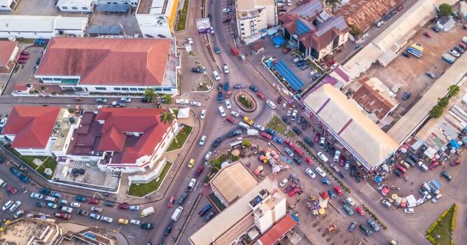 Aerial view of a busy urban intersection with a roundabout numerous cars and surrounding commercial buildings in Ghana. Aerial view of a busy urban intersection with a roundabout numerous cars and surrounding commercial buildings in Ghana.