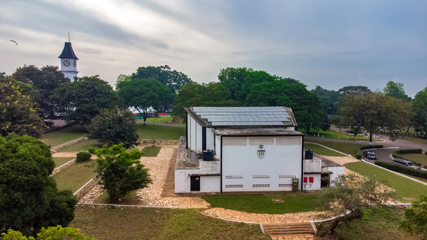 Aerial view of Achimota School featuring a white building with solar panels surrounded by lush green trees and a clock tower in Achimota Greater Accra Region Ghana. Aerial view of Achimota School featuring a white building with solar panels surrounded by lush green trees and a clock tower in Achimota Greater Accra Region Ghana.