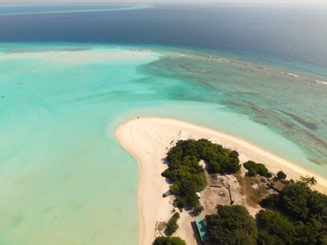 Aerial view of where turquoise waters meet the pristine white sands of the beach a tropical haven under the vast Maldivian sky Vashafaru Island Maldives.