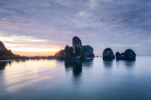 Aerial view of Railay Beach with dramatic limestone cliffs rising from the calm sea during a golden sunset in Ao Nang Krabi Thailand. Aerial view of Railay Beach with dramatic limestone cliffs rising from the calm sea during a golden sunset in Ao Nang Krabi Thailand.