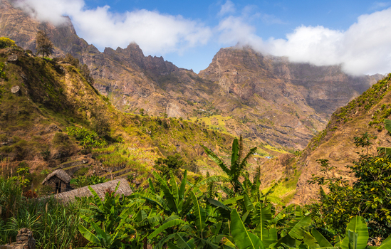 Aerial view of Trilha do Vale do Paul winding through lush green mountains banana plantations and traditional stone houses in Faja de Cima Paul Cabo Verde.