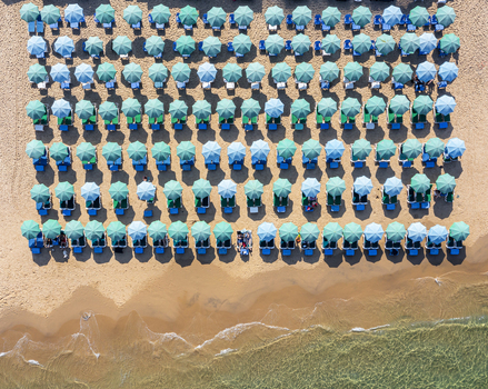 Aerial view of Bat Yam beach with rows of turquoise and light blue umbrellas on the sand by the sea with people relaxing under the sunshades Bat Yam Center District Israel. Aerial view of Bat Yam beach with rows of turquoise and light blue umbrellas on the sand by the sea with people relaxing under the sunshades Bat Yam Center District Israel.