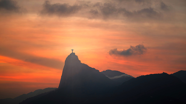 View of the silhouette of Christ the Redeemer statue on Corcovado mountain under a dramatic orange sunset sky in Rio de Janeiro Rio de Janeiro Brazil.