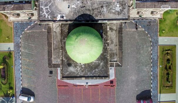 Aerial view of the An Nur Great Mosque featuring its prominent green dome surrounded by paved courtyards and landscaped gardens in Pekanbaru Riau Indonesia. Aerial view of the An Nur Great Mosque featuring its prominent green dome surrounded by paved courtyards and landscaped gardens in Pekanbaru Riau Indonesia.