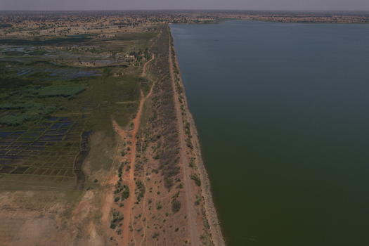 Aerial view of Minjibir Dam with its long embankment separating the calm water from agricultural fields and arid landscape Kano City Kano State Nigeria. Aerial view of Minjibir Dam with its long embankment separating the calm water from agricultural fields and arid landscape Kano City Kano State Nigeria.