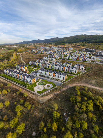 Aerial view of Residential Park Lozen featuring modern colorful houses manicured green spaces and paved roads nestled in a hilly landscape near Sofia Sofia City Province Bulgaria. Aerial view of Residential Park Lozen featuring modern colorful houses manicured green spaces and paved roads nestled in a hilly landscape near Sofia Sofia City Province Bulgaria.