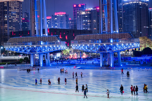 Guangzhou China 24 February 2024 View of the illuminated public plaza at Haixinsha Asian Games Park with people walking across the patterned ground at night. Guangzhou China 24 February 2024 View of the illuminated public plaza at Haixinsha Asian Games Park with people walking across the patterned ground at night.