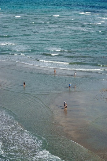 Aerial view of the beach with the waves crashing onto the shore people enjoying the sun Jupiter Beach Florida United States. Aerial view of the beach with the waves crashing onto the shore people enjoying the sun Jupiter Beach Florida United States.