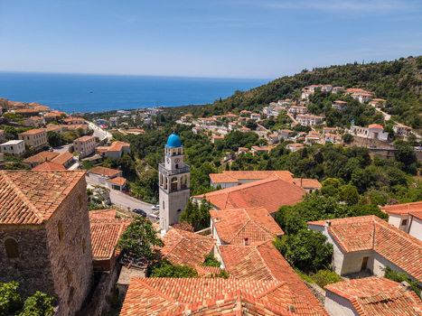 Aerial view of the village with its traditional terracotta rooftops and a white church tower with a blue dome overlooking the sea Dhermi Vlore County Albania.