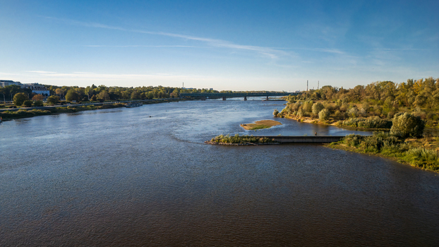 Aerial view of the Vistula River winding through the city with bridges connecting the tree lined banks under a clear blue sky Warsaw Poland. Aerial view of the Vistula River winding through the city with bridges connecting the tree lined banks under a clear blue sky Warsaw Poland.