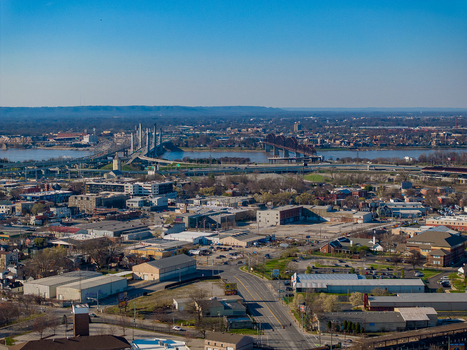 Aerial view of the urban skyline and bridges crossing the Ohio River under a clear blue sky in Louisville Kentucky United States.