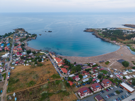 Aerial view of Arapya beach with its crescent shaped bay surrounding holiday houses parking area and calm sea in Burgas Bulgaria. Aerial view of Arapya beach with its crescent shaped bay surrounding holiday houses parking area and calm sea in Burgas Bulgaria.