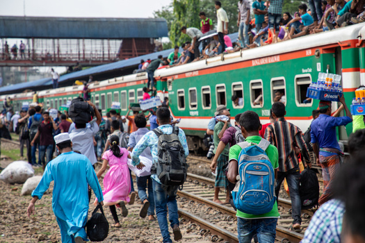 Dhaka Bangladesh 14 June 2018 View of passengers running alongside a crowded train with people sitting on the roof at Airport Railway Station. Dhaka Bangladesh 14 June 2018 View of passengers running alongside a crowded train with people sitting on the roof at Airport Railway Station.