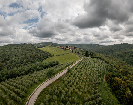 Aerial view of the rolling hills of Tuscany featuring olive groves a winding road and the historic village of Passignano Passignano Toscana Italy. Aerial view of the rolling hills of Tuscany featuring olive groves a winding road and the historic village of Passignano Passignano Toscana Italy.