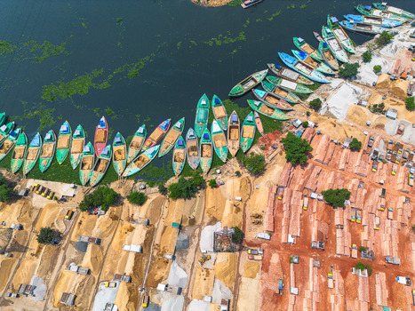Aerial view of boats lined up alongside the muddy bank juxtaposed with piles of bricks and sand creating a textured landscape Dhaka Dhaka Division Bangladesh. Aerial view of boats lined up alongside the muddy bank juxtaposed with piles of bricks and sand creating a textured landscape Dhaka Dhaka Division Bangladesh.