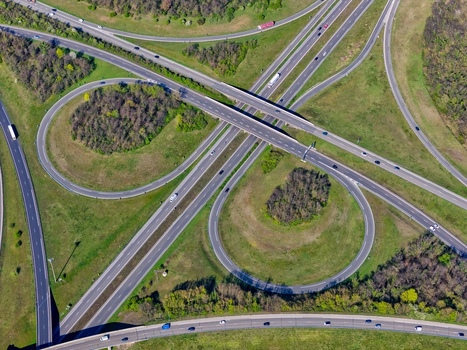 Aerial view of the intricate cloverleaf interchange a symphony of concrete curves amidst verdant fields and scattered trees Sausheim Grand Est France.