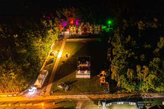 Herzogenaurach Germany 25 July 2025 Aerial view of the Open Beatz Festival stage illuminated with vibrant lights and surrounded by dark forest at night. Herzogenaurach Germany 25 July 2025 Aerial view of the Open Beatz Festival stage illuminated with vibrant lights and surrounded by dark forest at night.