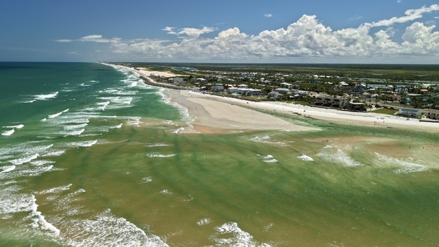 Aerial view of Matanzas Inlet showing the coastline sandy beach turquoise ocean waters and coastal residential area in St. Johns County Florida United States. Aerial view of Matanzas Inlet showing the coastline sandy beach turquoise ocean waters and coastal residential area in St. Johns County Florida United States.