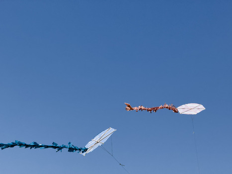 View of two colorful kites with long decorative tails flying against a clear blue sky on a sunny day in Avcilar Istanbul Turkiye. View of two colorful kites with long decorative tails flying against a clear blue sky on a sunny day in Avcilar Istanbul Turkiye.