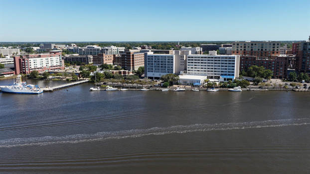 Aerial view of the Wilmington riverfront along the Cape Fear River featuring hotels buildings and boats docked at the pier in Wilmington North Carolina United States.