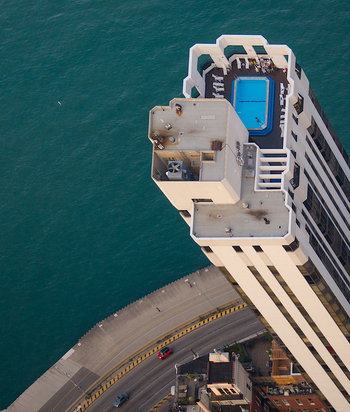 Aerial view of the Lake Point Tower rooftop featuring a blue swimming pool and lounge chairs overlooking Lake Michigan and the city streets in Chicago Illinois United States. Aerial view of the Lake Point Tower rooftop featuring a blue swimming pool and lounge chairs overlooking Lake Michigan and the city streets in Chicago Illinois United States.
