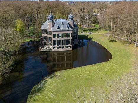 Aerial view of the magnificent castle reflecting softly on the moat s dark waters surrounded by verdant lawns and trees Oegstgeest Zuid Holland Netherlands. Aerial view of the magnificent castle reflecting softly on the moat s dark waters surrounded by verdant lawns and trees Oegstgeest Zuid Holland Netherlands.