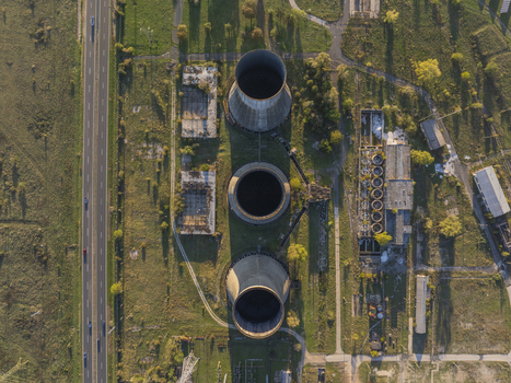 Aerial view of the abandoned Inota Power Plant cooling towers surrounded by overgrown fields and industrial ruins in Varpalota Hungary. Aerial view of the abandoned Inota Power Plant cooling towers surrounded by overgrown fields and industrial ruins in Varpalota Hungary.