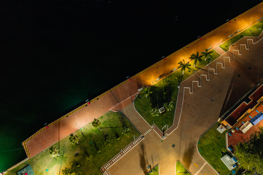 Aerial view of Decima Segunda Zona Naval at night with illuminated promenade palm trees and waterfront in Puerto Vallarta Jalisco Mexico.