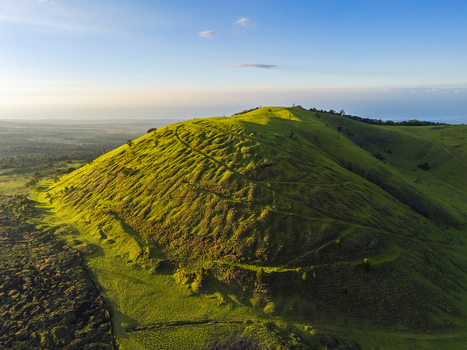Aerial view of the Puu Waawaa cinder cone featuring lush green slopes and textured ridges under golden hour light Hawaii County Hawaii United States. Aerial view of the Puu Waawaa cinder cone featuring lush green slopes and textured ridges under golden hour light Hawaii County Hawaii United States.