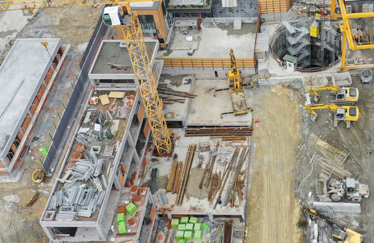 Aerial view of a busy construction site featuring yellow cranes excavators and concrete building foundations under development Avcilar Istanbul Turkiye. Aerial view of a busy construction site featuring yellow cranes excavators and concrete building foundations under development Avcilar Istanbul Turkiye.