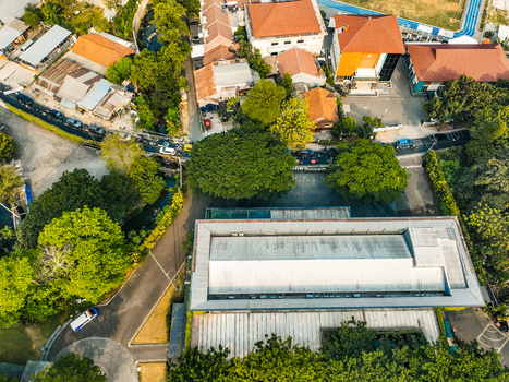 Aerial view of The Pavilion Venue surrounded by lush trees residential rooftops and local roads in Kecamatan Ciputat Timur Banten Indonesia. Aerial view of The Pavilion Venue surrounded by lush trees residential rooftops and local roads in Kecamatan Ciputat Timur Banten Indonesia.