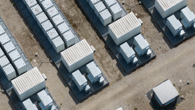 Aerial view of rows of white industrial battery storage containers arranged on a gravel surface at a utility site in Wanneperveen Overijssel Netherlands. Aerial view of rows of white industrial battery storage containers arranged on a gravel surface at a utility site in Wanneperveen Overijssel Netherlands.