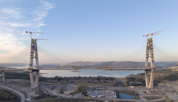 Aerial view of a large cable stayed bridge under construction with tall concrete pylons and cranes spanning across a body of water in Istanbul Istanbul Turkiye.
