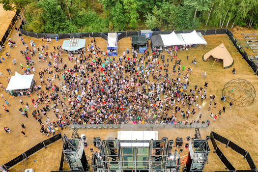 Herzogenaurach Germany 22 July 2022 Aerial view of the Open Beatz Festival with a large crowd gathered in front of a stage surrounded by white tents and lush green trees. Herzogenaurach Germany 22 July 2022 Aerial view of the Open Beatz Festival with a large crowd gathered in front of a stage surrounded by white tents and lush green trees.