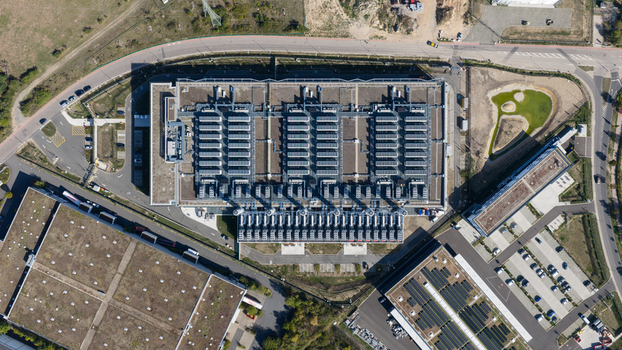 Aerial view of a large industrial facility with extensive rooftop HVAC units surrounding parking lots and green areas in Dietzenbach Hessen Germany. Aerial view of a large industrial facility with extensive rooftop HVAC units surrounding parking lots and green areas in Dietzenbach Hessen Germany.