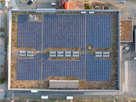Aerial view of a large solar panel array installed on a green roof of a commercial building in Etoy Vaud Switzerland.