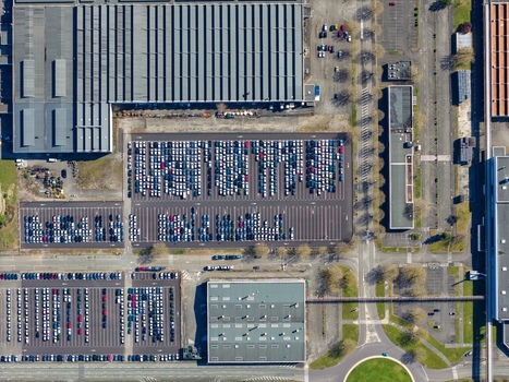 Aerial view of densely packed cars in orderly rows contrasting with the surrounding industrial architecture Sausheim Grand Est France.