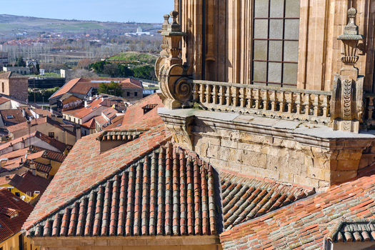 Salamanca Spain 01 December 2025 View of the Pontifical University of Salamanca featuring ornate stone carvings and a balcony overlooking the historic terracotta rooftops of the city. Salamanca Spain 01 December 2025 View of the Pontifical University of Salamanca featuring ornate stone carvings and a balcony overlooking the historic terracotta rooftops of the city.