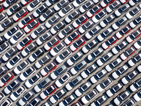 Aerial view of rows of new cars parked in an orderly fashion at a logistics terminal in Vado Ligure Liguria Italy.