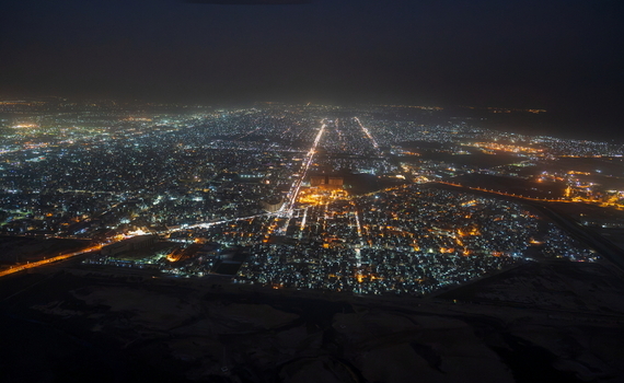 Aerial view of the sprawling city lights of Karachi at night with illuminated streets and dense urban infrastructure stretching across the landscape in Karachi Sindh Pakistan.