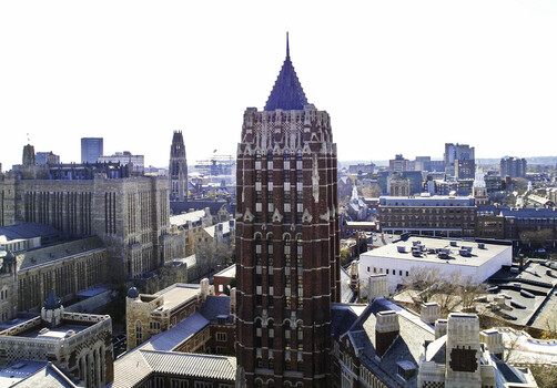 Aerial view of the Humanities Quadrangle and Swensen Tower at Yale University featuring gothic architecture brick buildings and the cityscape in New Haven Connecticut United States.