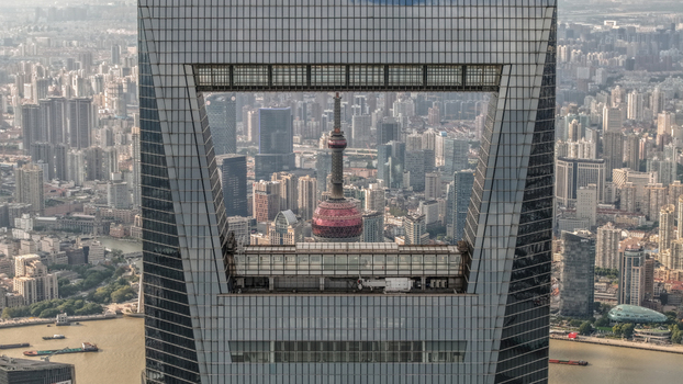 Aerial view of the Oriental Pearl Tower framed through the Shanghai World Financial Center aperture overlooking the Lujiazui skyline and Huangpu River. Shanghai Shanghai China.