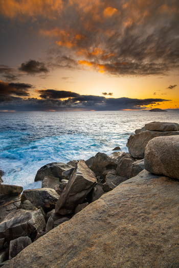 View of the rocky coastline at Torndirrup National Park with crashing waves and a dramatic sunset sky in Torndirrup Western Australia Australia.