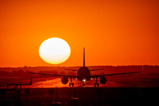 View of a commercial airplane silhouette on the runway at sunset at Bucharest Henri Coanda International Airport in Otopeni Judetul Ilfov Romania. View of a commercial airplane silhouette on the runway at sunset at Bucharest Henri Coanda International Airport in Otopeni Judetul Ilfov Romania.