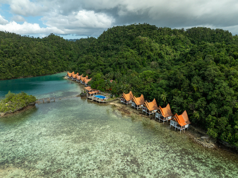 Aerial view of Bucas Grande featuring stilt cottages with orange roofs nestled along the lush tropical coastline surrounded by clear turquoise waters Siargao Philippines. Aerial view of Bucas Grande featuring stilt cottages with orange roofs nestled along the lush tropical coastline surrounded by clear turquoise waters Siargao Philippines.