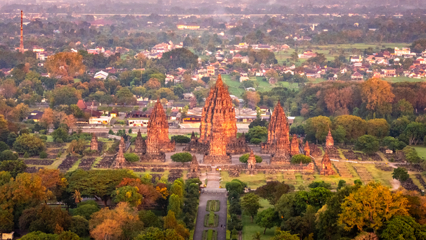 Aerial view of Prambanan Temple complex with its towering stone spires illuminated by golden sunset light in Kecamatan Prambanan Daerah Istimewa Yogya Indonesia. Aerial view of Prambanan Temple complex with its towering stone spires illuminated by golden sunset light in Kecamatan Prambanan Daerah Istimewa Yogya Indonesia.