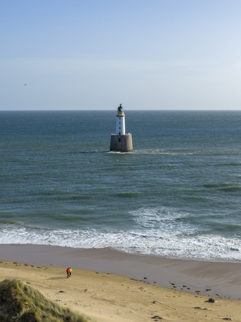 Aerial view of Rattray Head Lighthouse standing in the North Sea with people walking on the sandy beach under a clear blue sky Peterhead Scotland United Kingdom. Aerial view of Rattray Head Lighthouse standing in the North Sea with people walking on the sandy beach under a clear blue sky Peterhead Scotland United Kingdom.