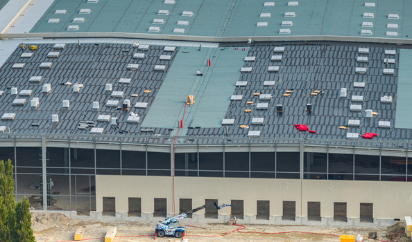 Aerial view of a logistics warehouse under construction featuring a modern distribution center with roofing works and industrial infrastructure in Loriol sur Drome Auvergne Rhone Alpes France.