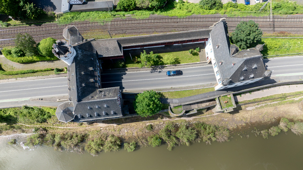 Aerial view of the historic Schloss Leyen castle complex with a main road passing through the courtyard and a car driving on the asphalt Kobern Gondorf Rheinland Pfalz Germany. Aerial view of the historic Schloss Leyen castle complex with a main road passing through the courtyard and a car driving on the asphalt Kobern Gondorf Rheinland Pfalz Germany.